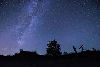 一个人在夜空中观看星星的剪影.